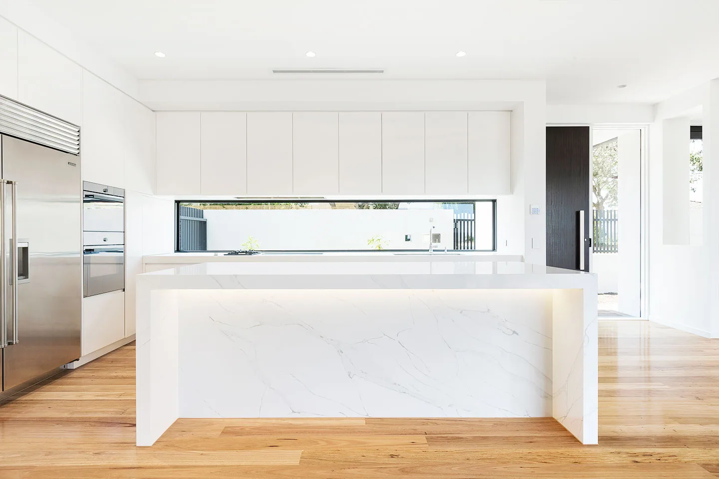 Modern kitchen with white cabinets and a large island
